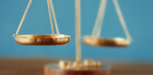 A gold balance scale on a wooden table, providing an effective valuation.