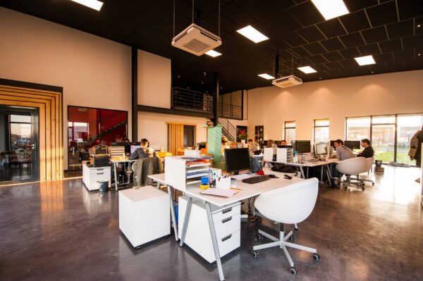 A large open office with people working at desks selling WordPress businesses.
